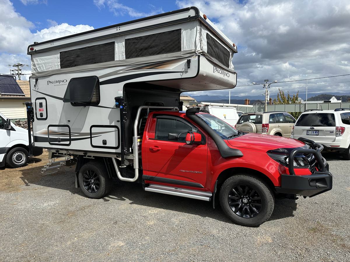 Red Holden Colorado single cab carrying a Palomino Backpack Edition slide-on camper, sold by Streets Automotives in Deloraine