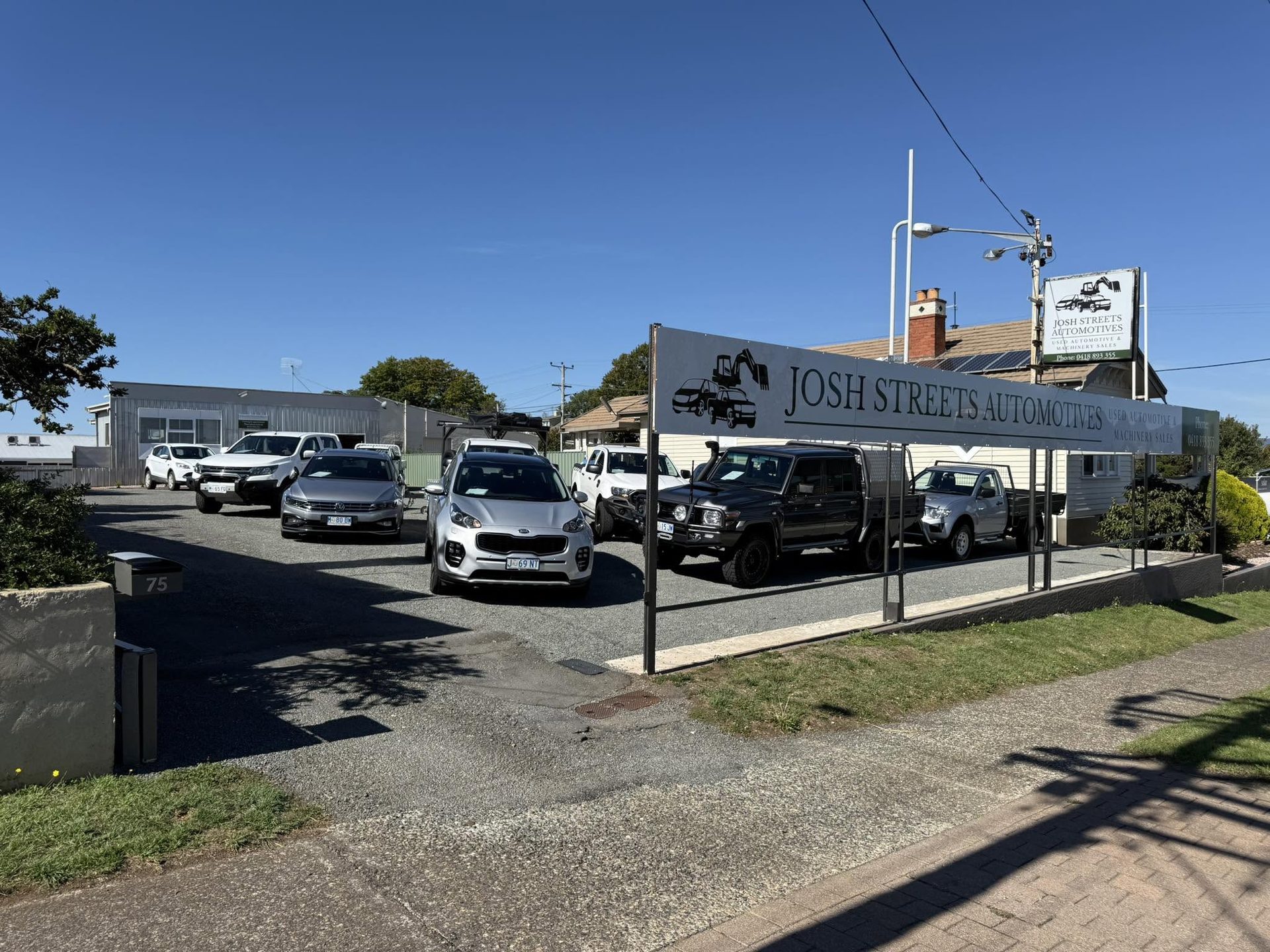 The Josh Streets Automotives sign above utes on the Deloraine yard